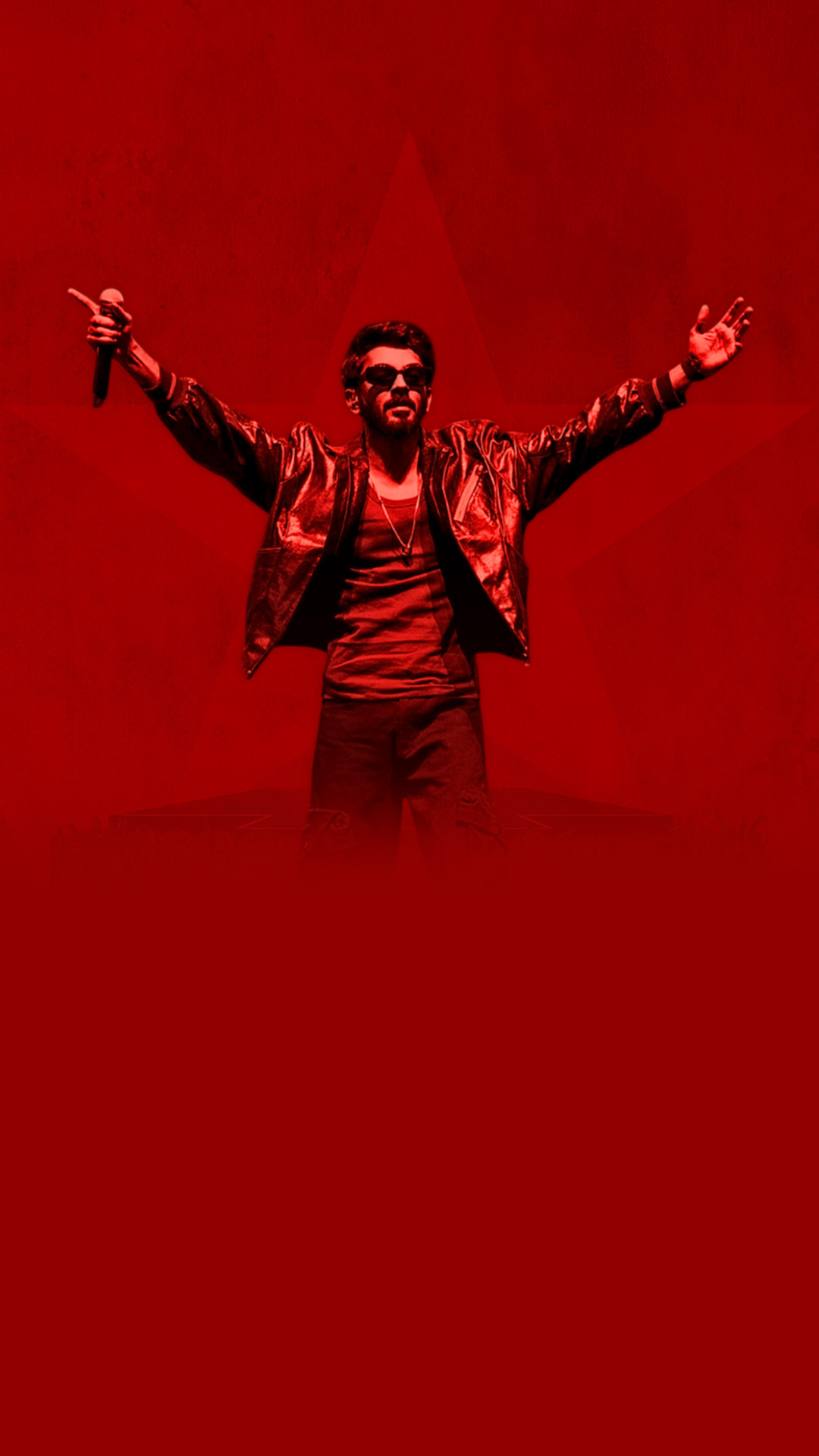 Singer Anirudh with microphone in hand and arms in the air against a red background.
