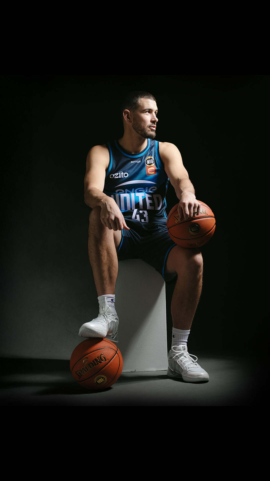 Melbourne United basketball Chris Goulding posing with two basketballs.
